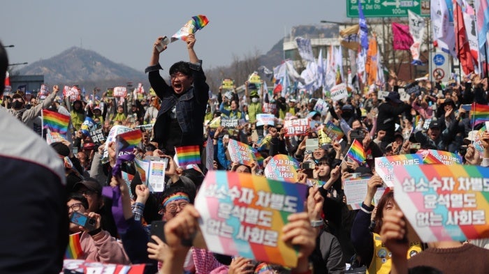 People celebrate after the Constitutional Court's ruling to remove President Yoon from office, near Anguk Station, Seoul, South Korea, on April 4, 2025. 