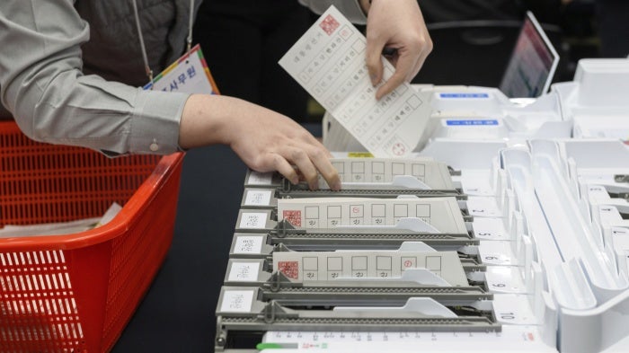 An official demonstrates the ballot counting process using a ballot sorting machine during a simulation of the presidential election voting and counting procedures at South Korea's National Election Commission, April 10, 2025. 