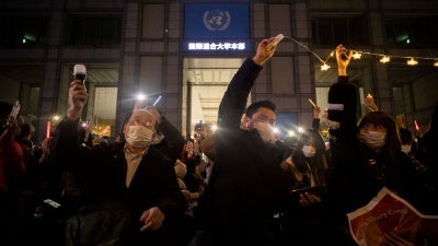 People protest outside a university building at night