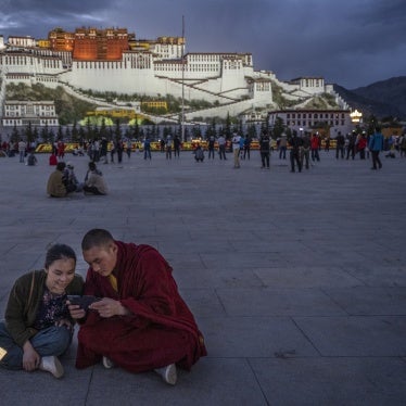 A Tibetan Buddhist monk and a woman share a mobile phone outside the Potala Palace in Lhasa, Tibet Autonomous Region, China, on June 1, 2021.